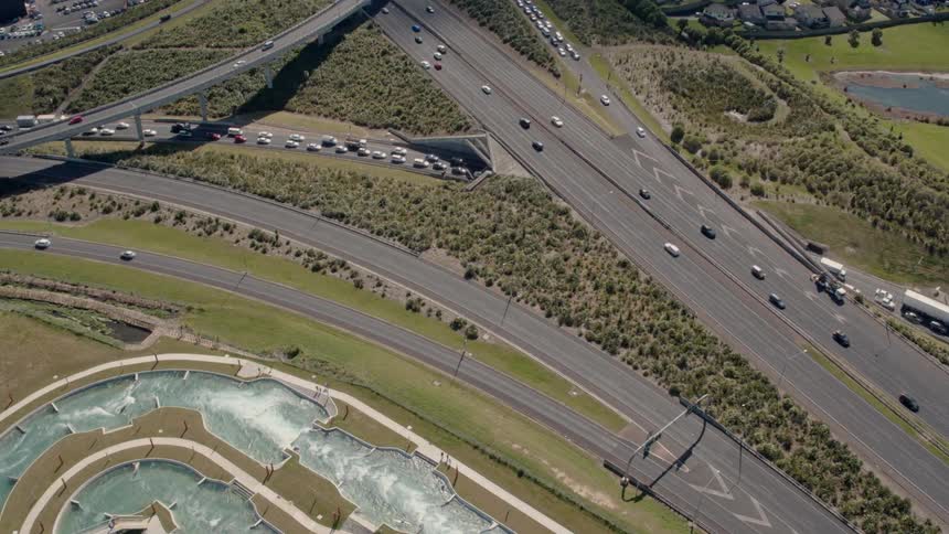 The cars travel down the highway on a sunny day