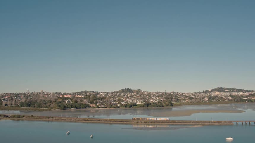 A large highway is surrounding by a large body of water