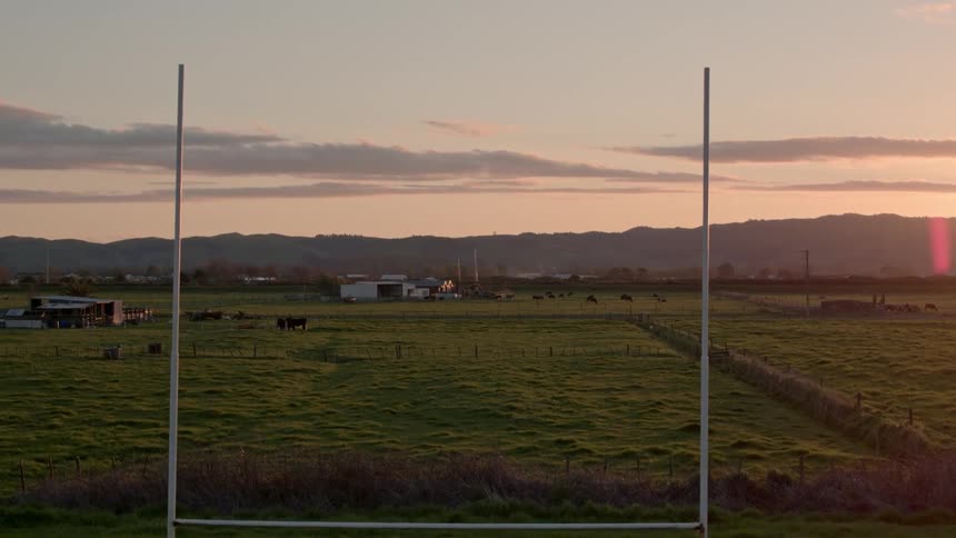 Goal post like structure in a field at sunset