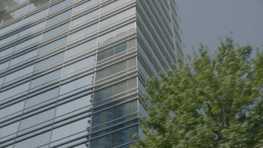 An office building is being filmed from a passing car