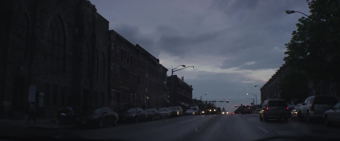 Driving up a city street on a cloudy evening