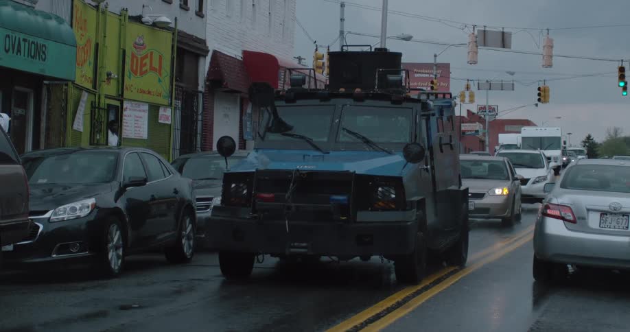 An armored vehicle travels down the street