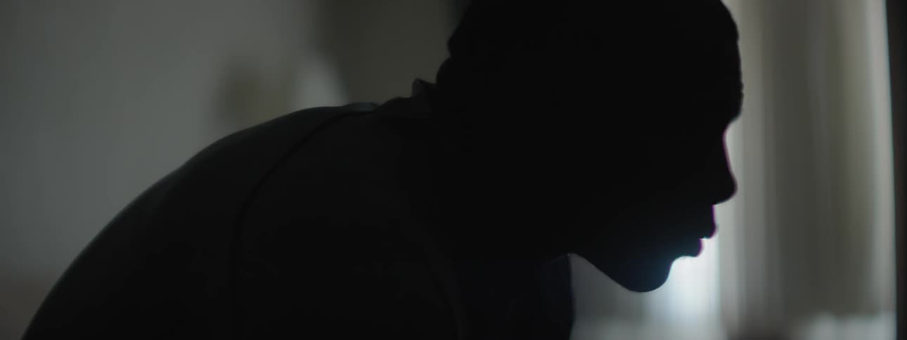 Silhouette of a man standing near a window