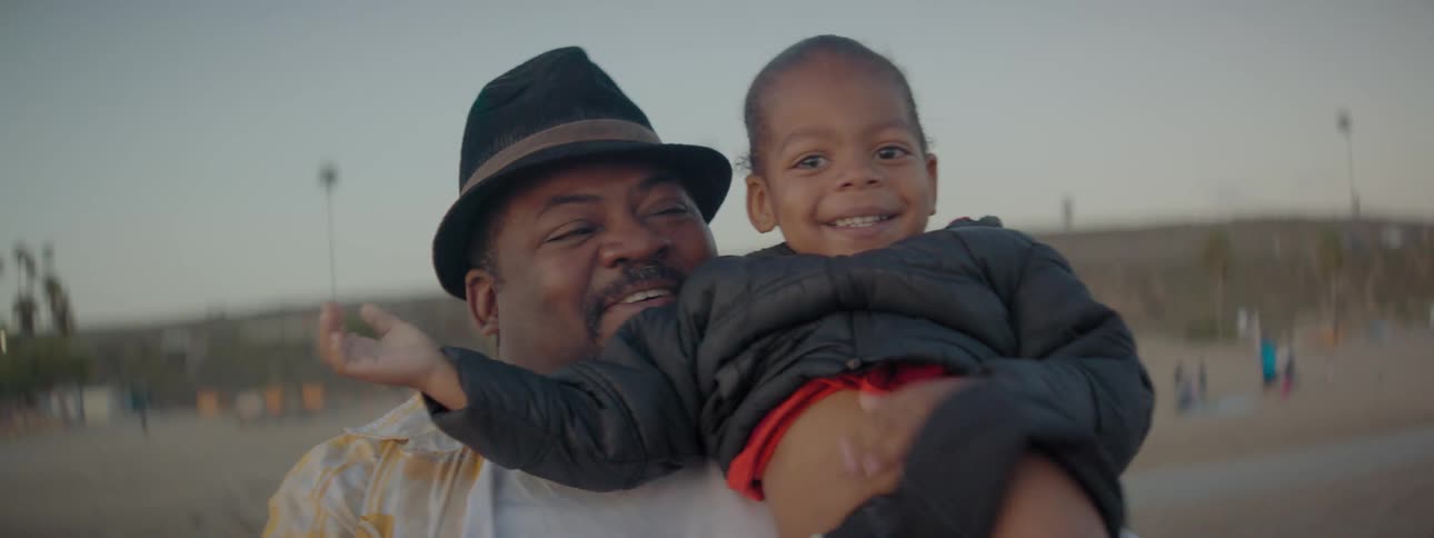 A man tosses a young girl into the air while they smile