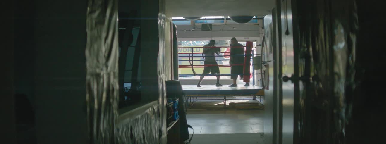Two people spar boxing in the ring