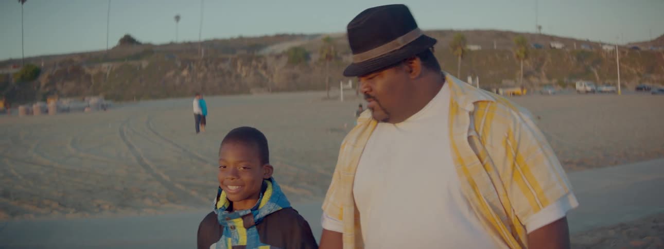 Man and child walk outside on the beach