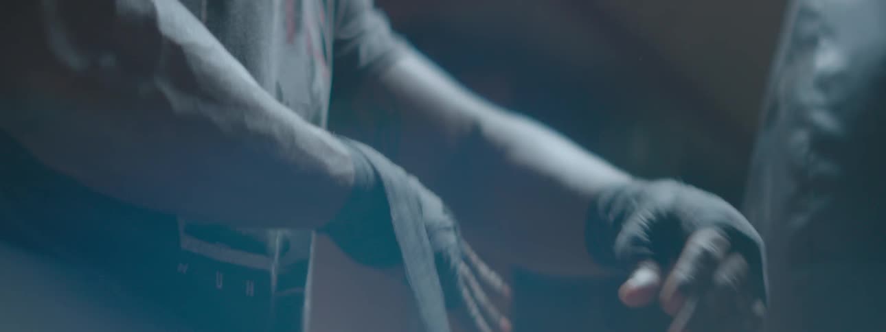 A man is taping up his wrist and hand