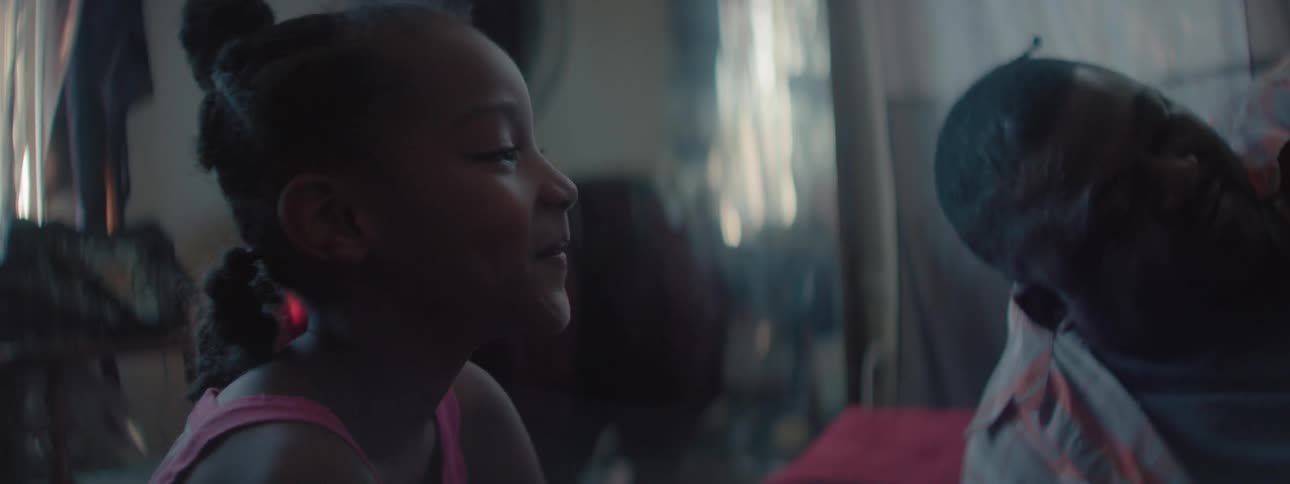 A young girl is sitting with her daddy and smiling