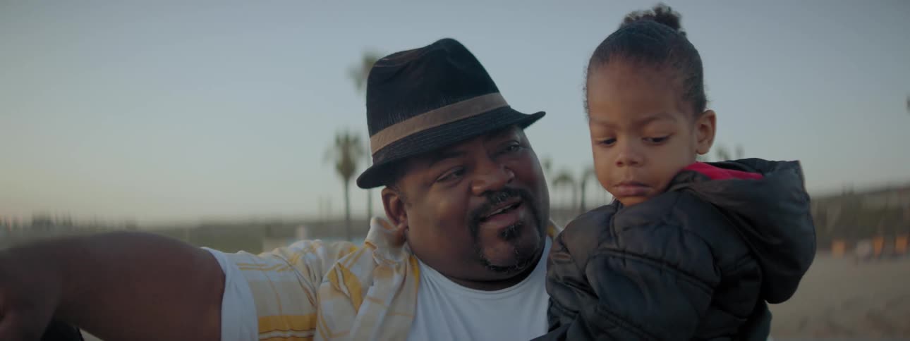 Man points while holding young girl