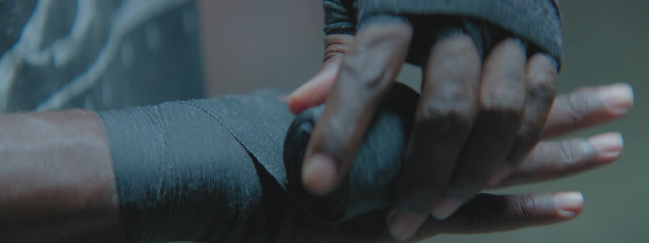 A man is taping up his hands in a gym