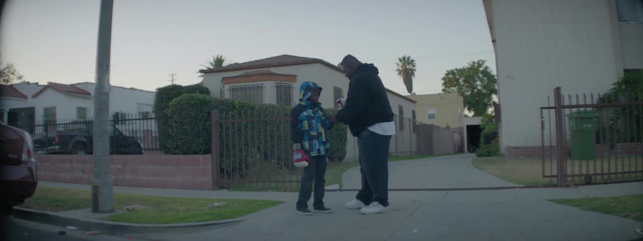 A man puts a boxing glove on a young boy