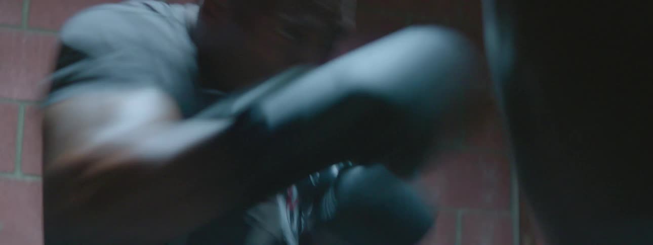 A man is boxing a heavy bag