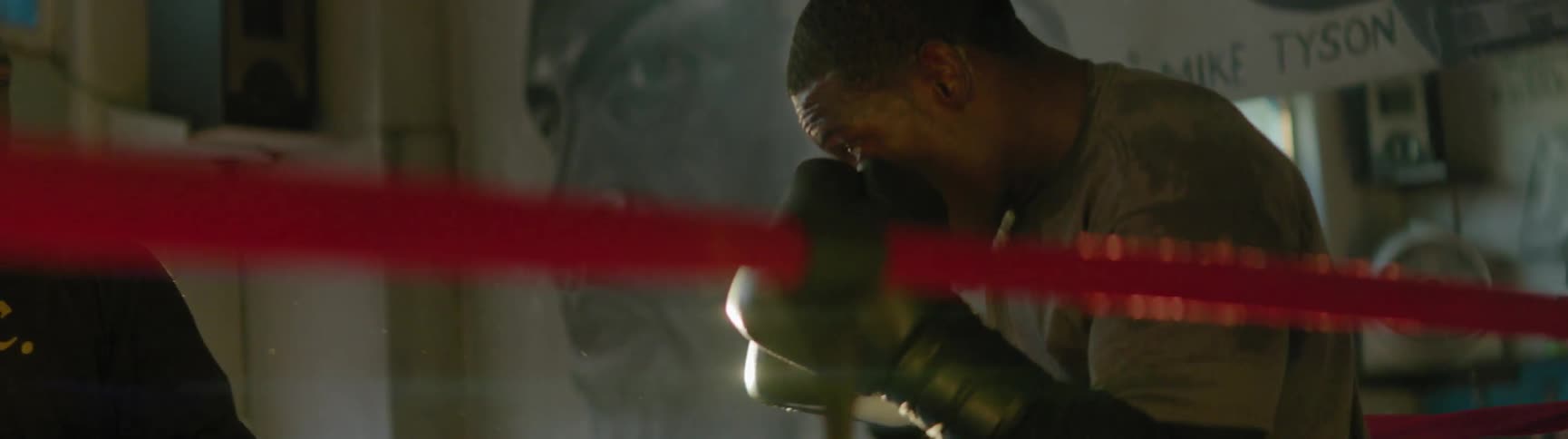 A man is practicing his boxing skills in the ring with his coach