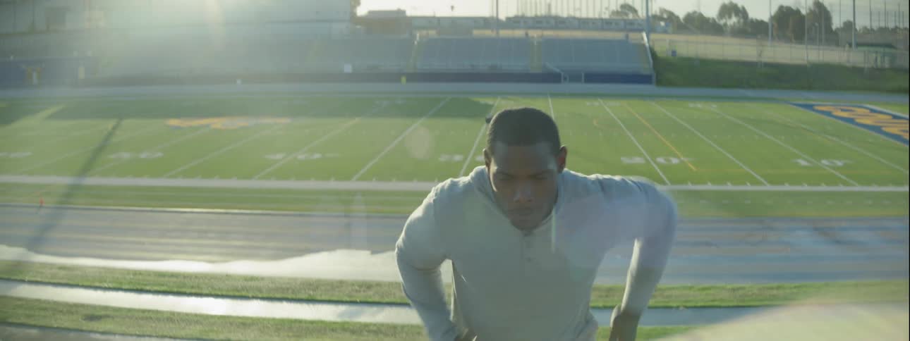 A man in sweats is running up the bleachers