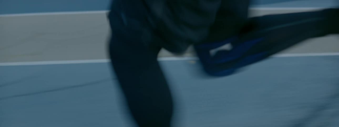 Man runs on a track next to bleachers