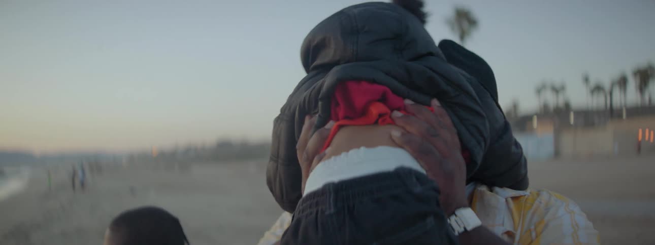 A man throws a child up in the air hugging her