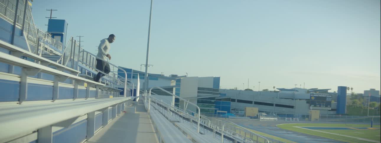 Man runs up and down the bleachers at a sports field