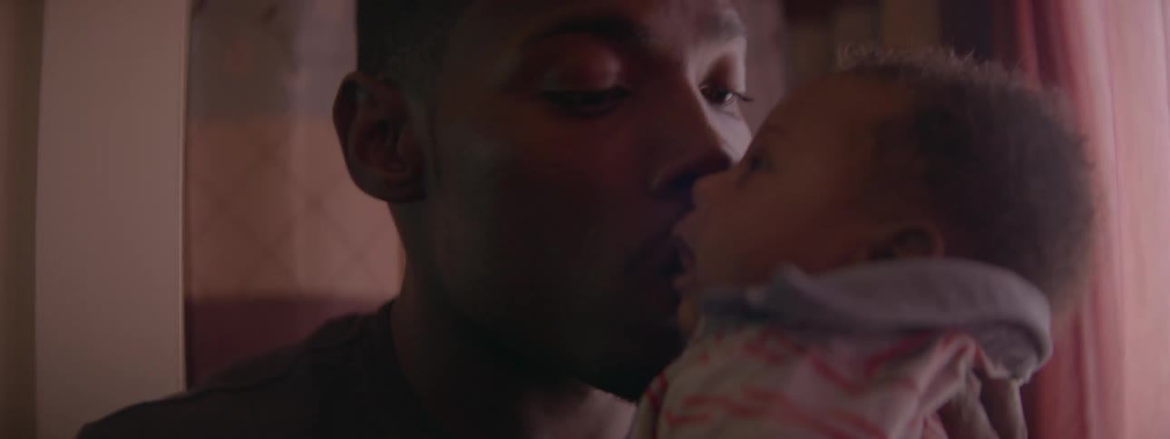 Man holds a baby and gives it a kiss