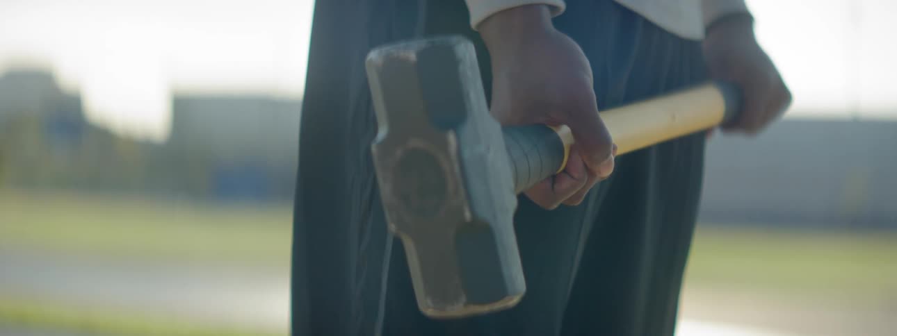 Man holds mallet and swings it downward