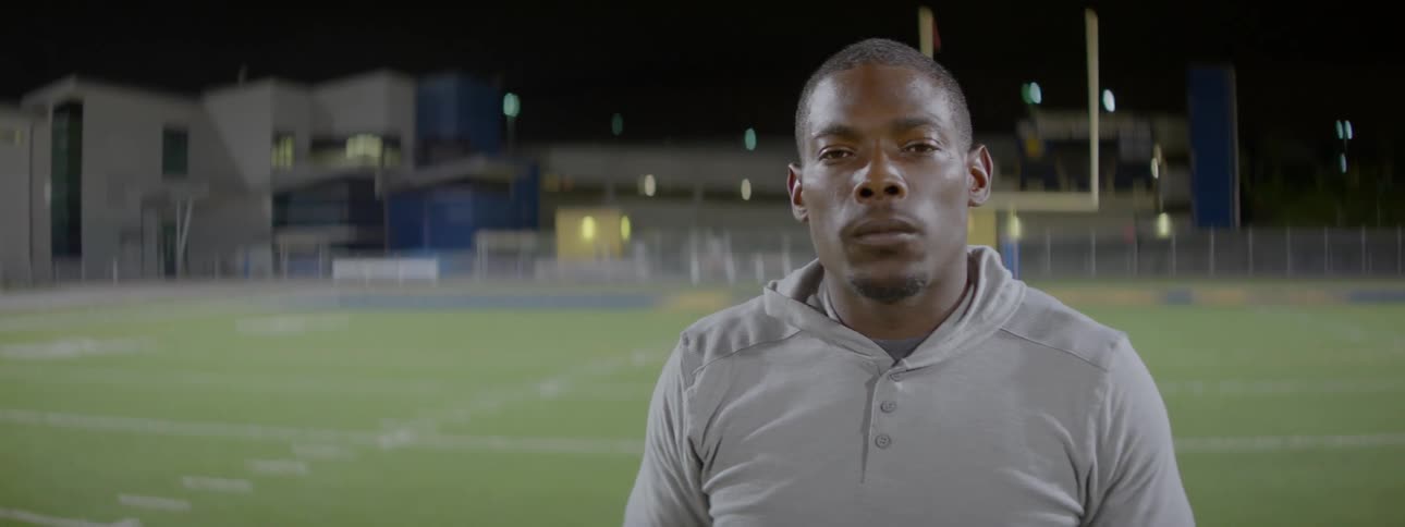 Man stands in the middle of a stadium at night
