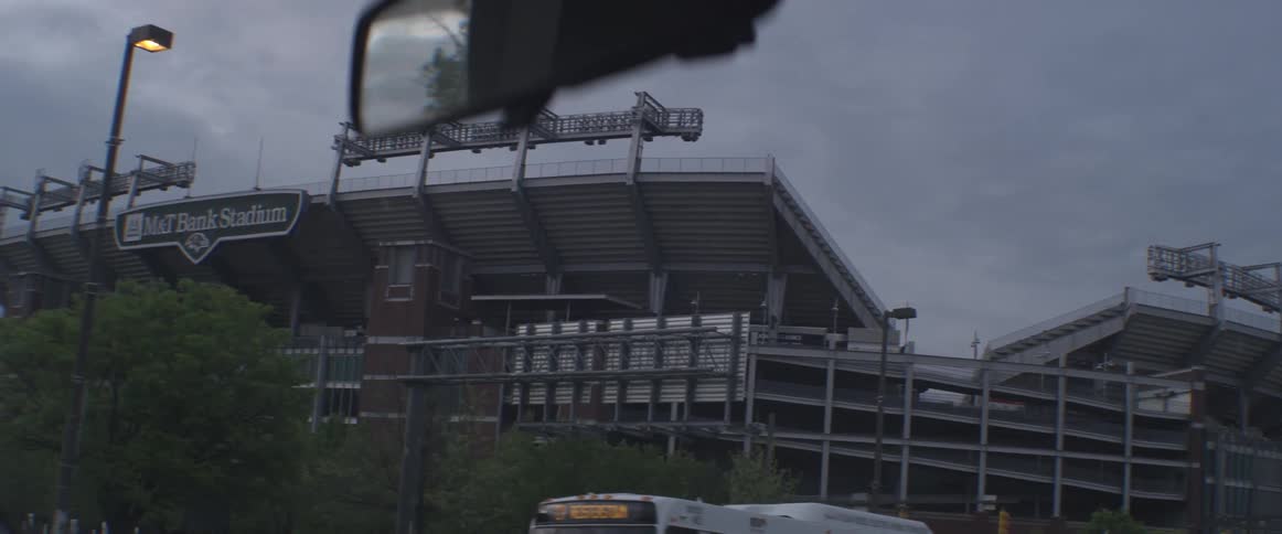A car approaches a large sports stadium