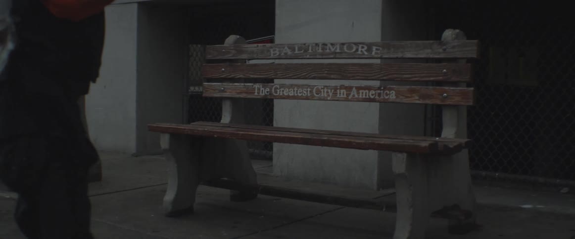 A man walks past a baltimore bench