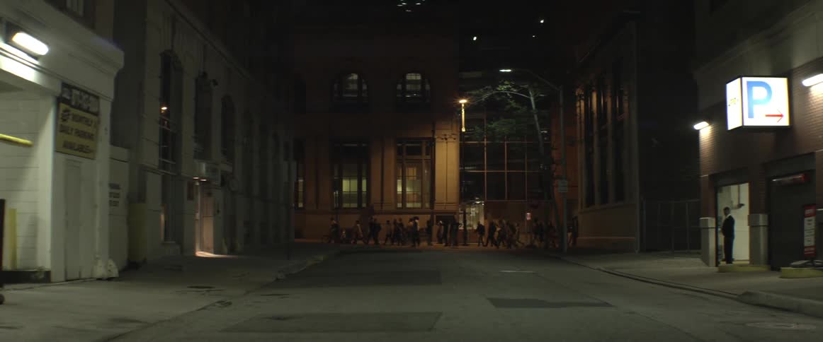 People walking down a sidewalk at night