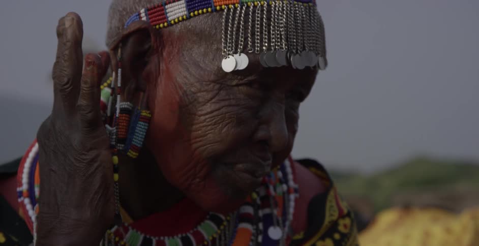 Maasai woman applies paint to her neck with her fingers