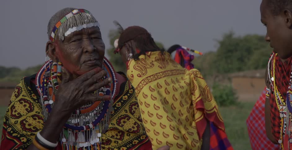 Maasai people apply face paint on a windy day