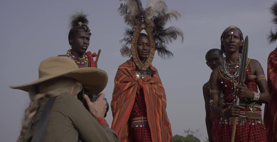 Maasai stand together wearing costumes as they are photographed