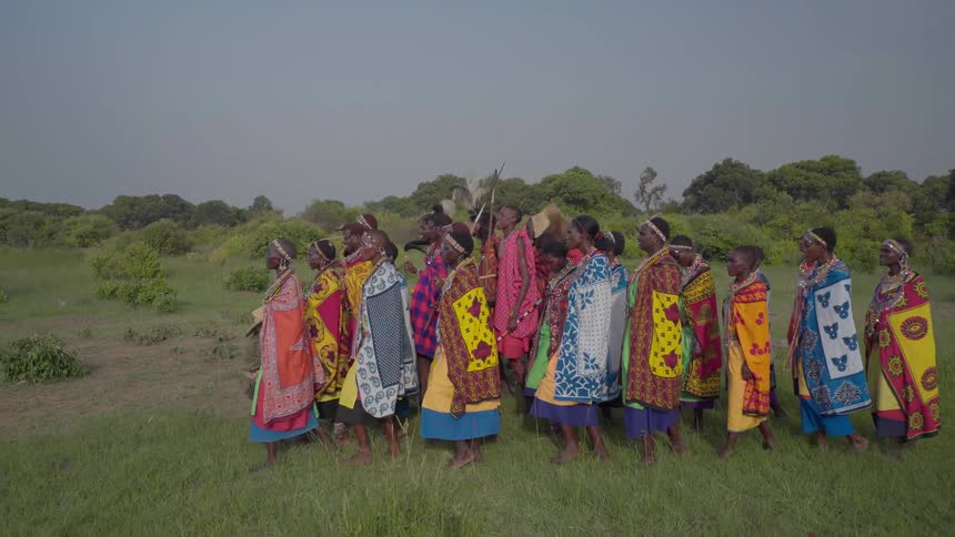 Maasai women dance through a field