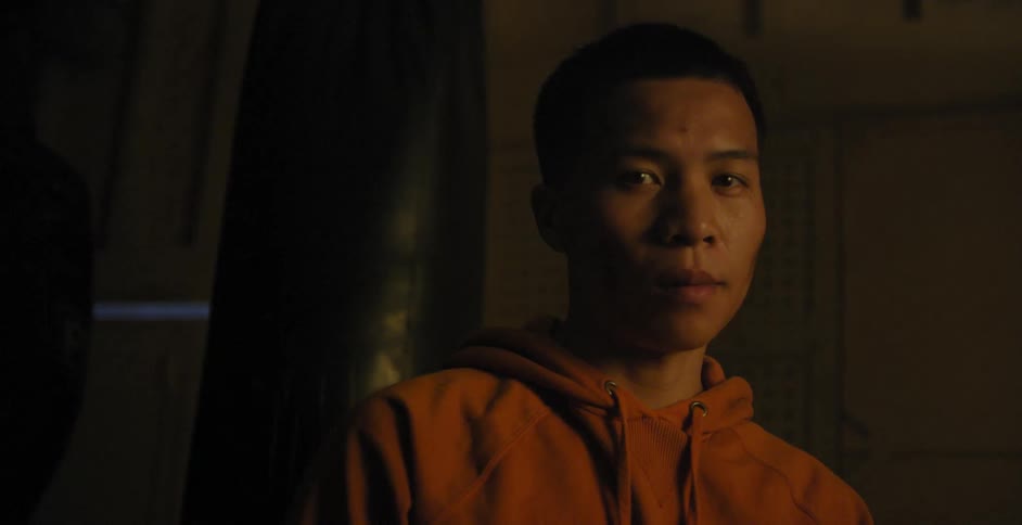 A man is standing in a dark room with flashing lights
