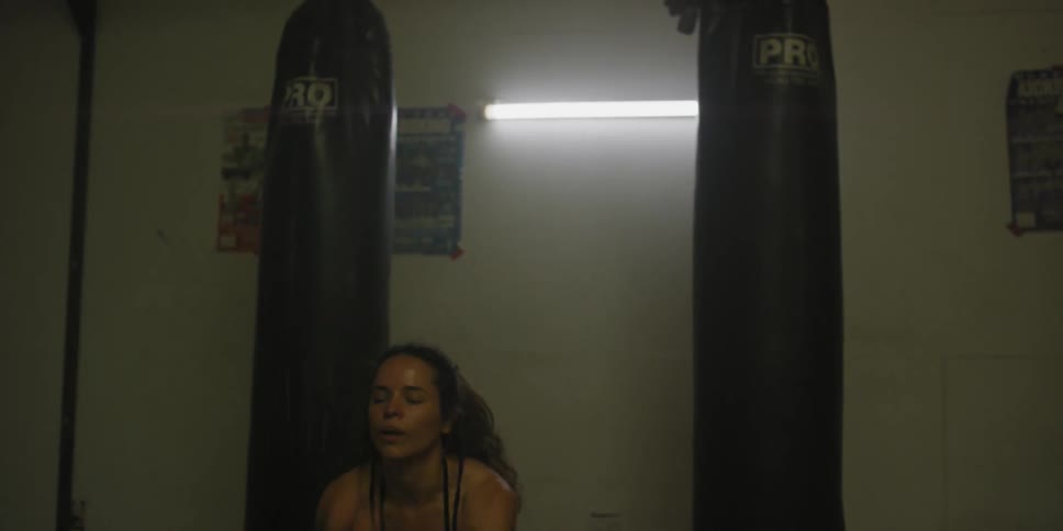 A woman jumps and exercises in a weight room