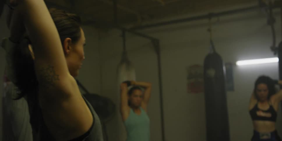 A group of fighters is stretching and warming up in a gym