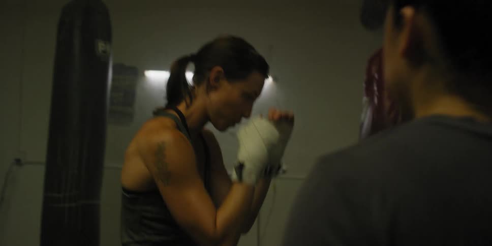 A woman practices shadow boxing in a gym