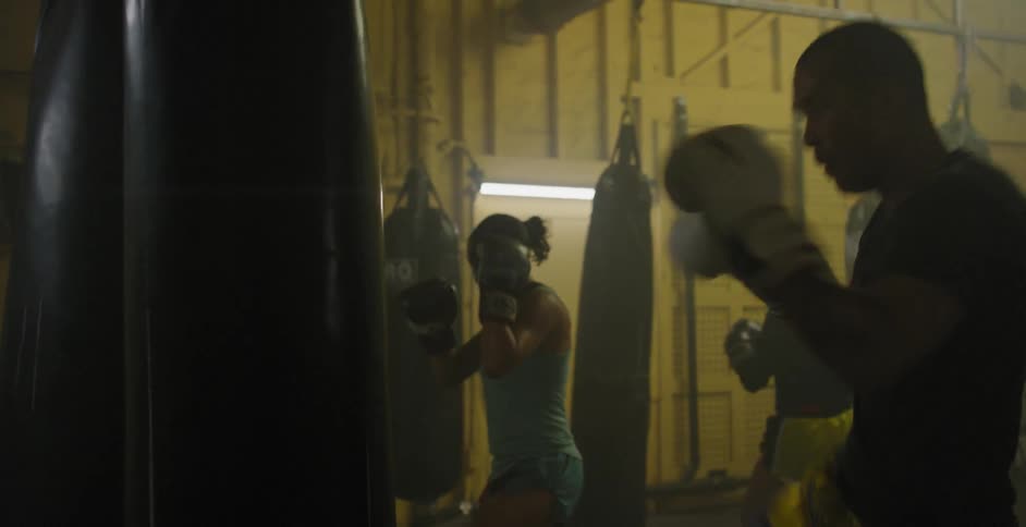 People hit punching bags in a gym