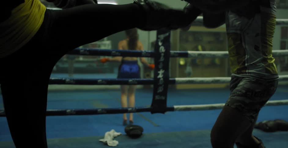 Two kick boxers are sparring in a ring
