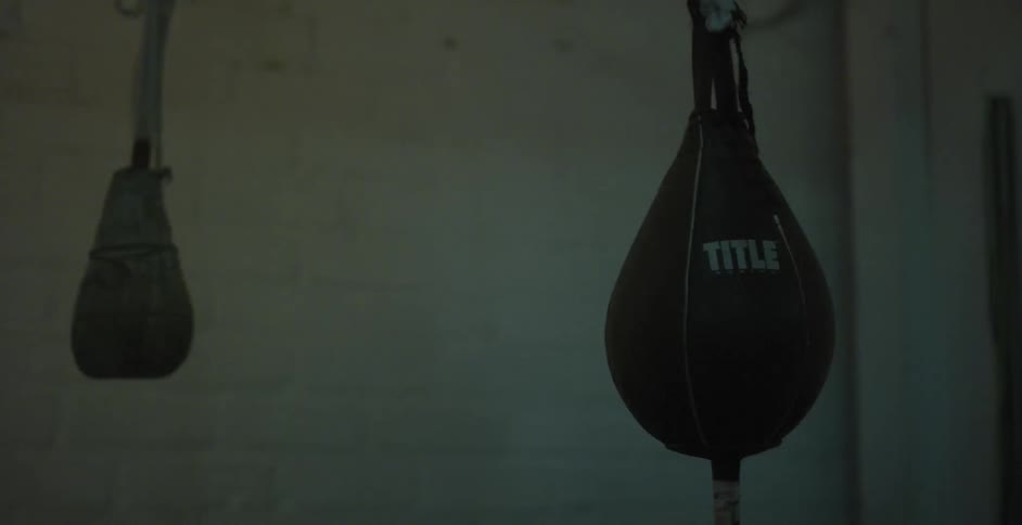 Some punching bags are swaying in a gym