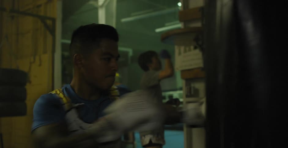 People are punching bags in a gym practicing