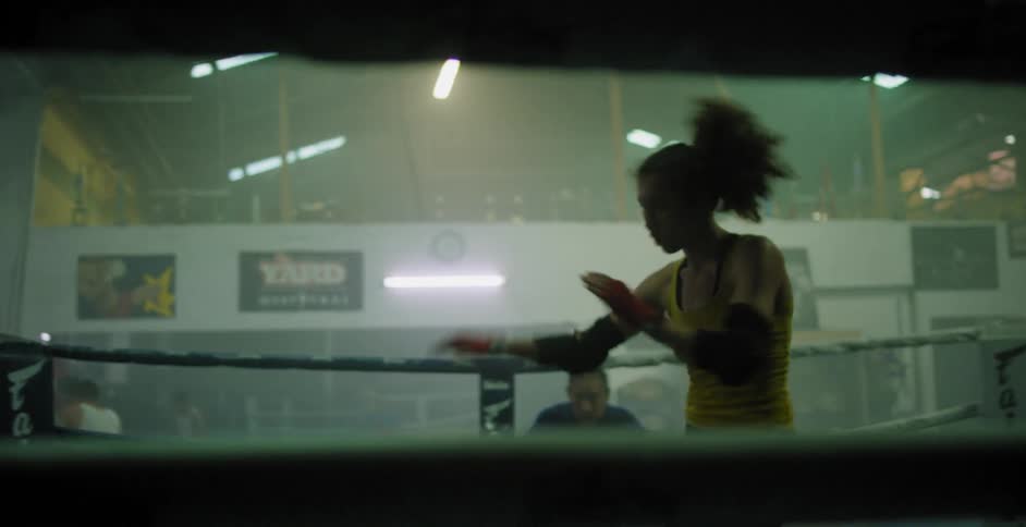 A woman is practicing kickboxing moves in a ring
