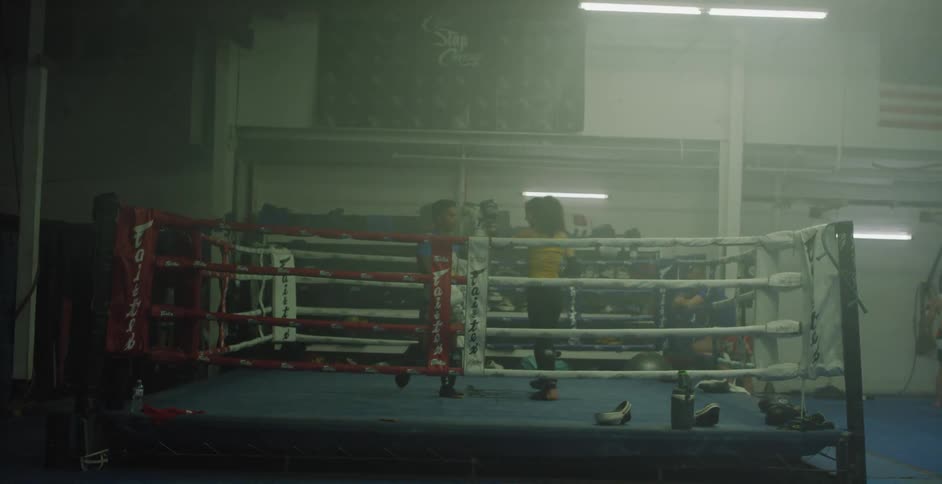 Two fighters approach each other and touch gloves in a boxing ring