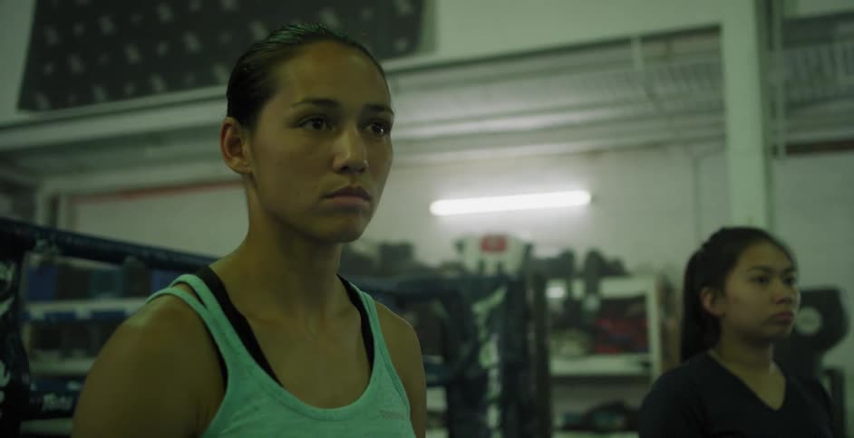 A couple of women are standing in a gym