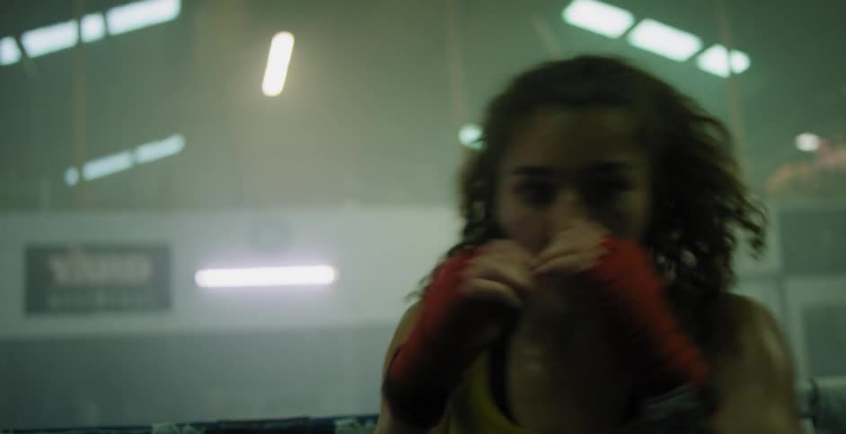 A woman shadow boxes in a ring