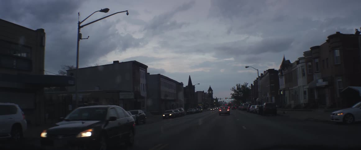 Cars on the road in a town at sunset