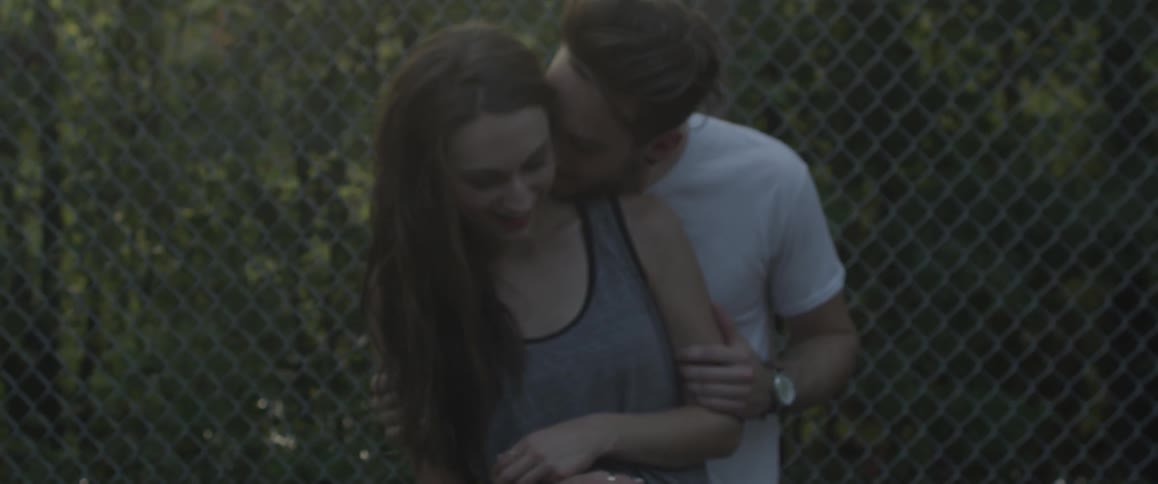 A man kisses a woman on the neck