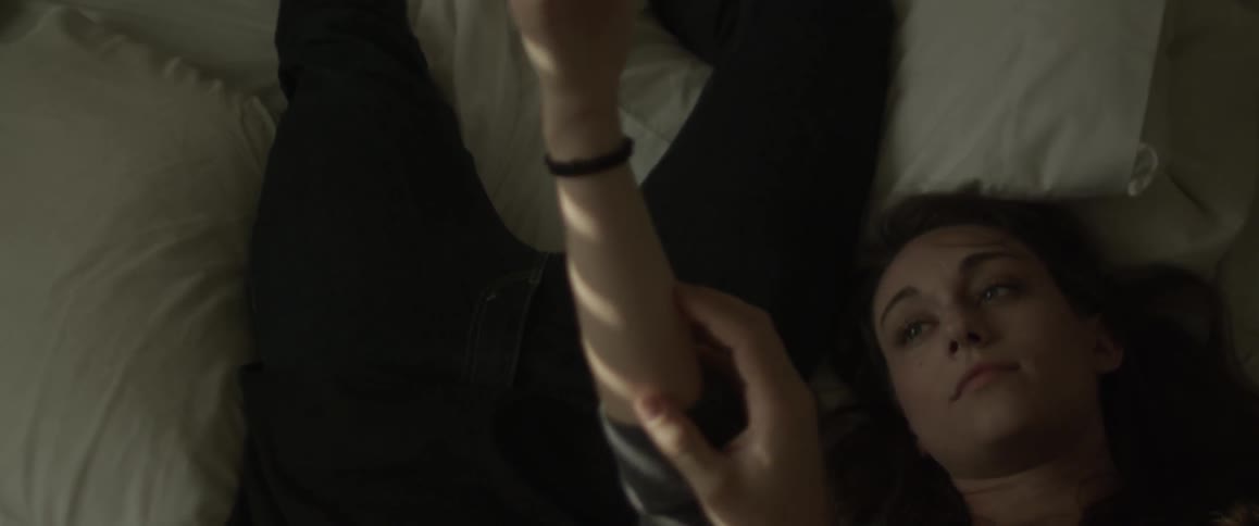 A man and woman are laying in bed playing with each others arms