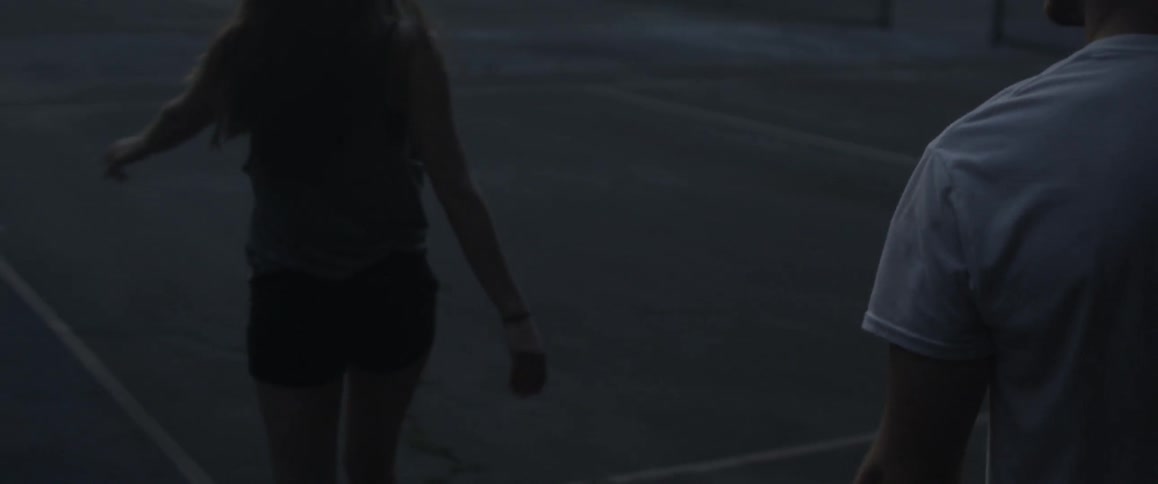 A couple dances in a parking lot