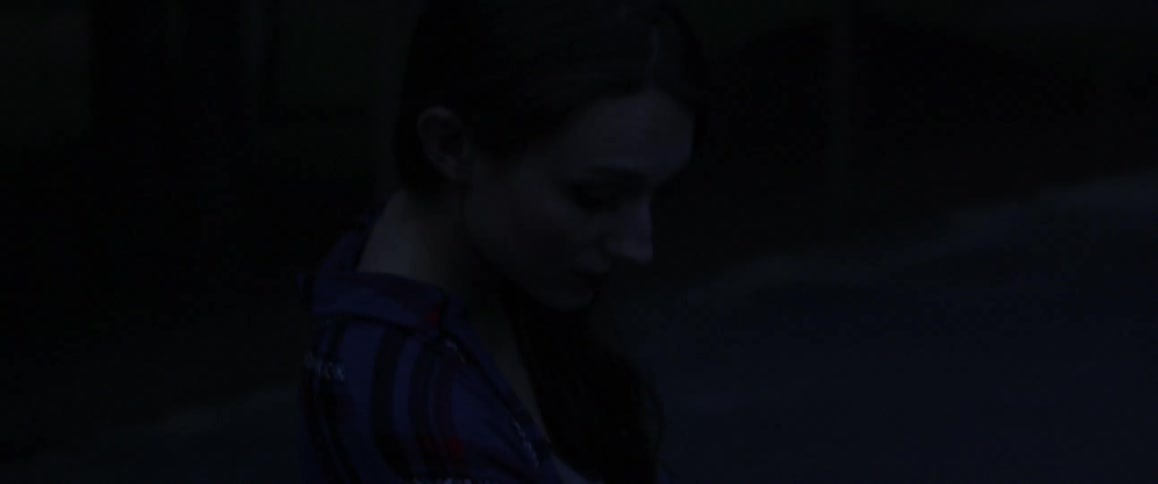 Person walking in a very dark area that appears to be outdoors