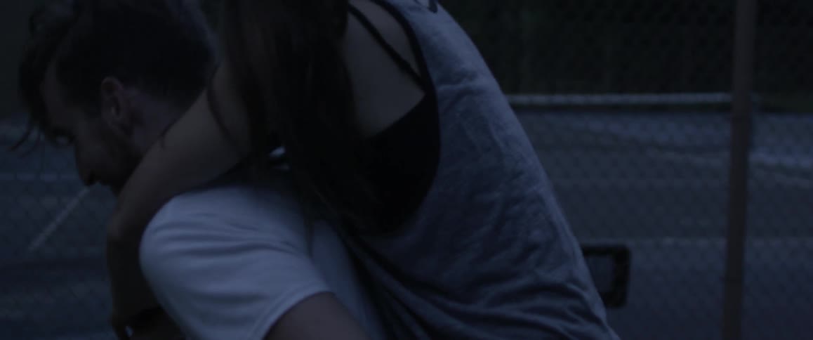 A man is giving a woman are piggy back ride through a park