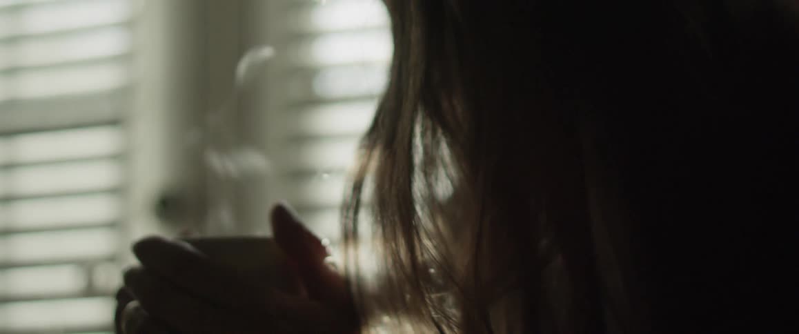 A person holds a steaming mug in their hands
